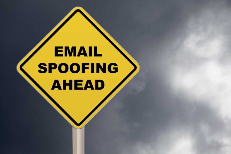 email spoofing feature image of a yellow caution sign that warns "email spoofing ahead"