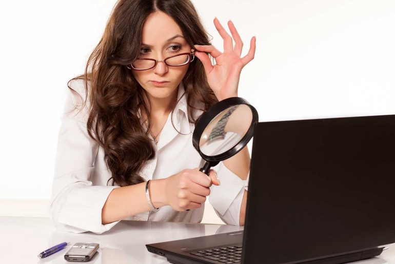 what is typosquatting feature image of a woman inspecting a suspicious website with a magnifying glass